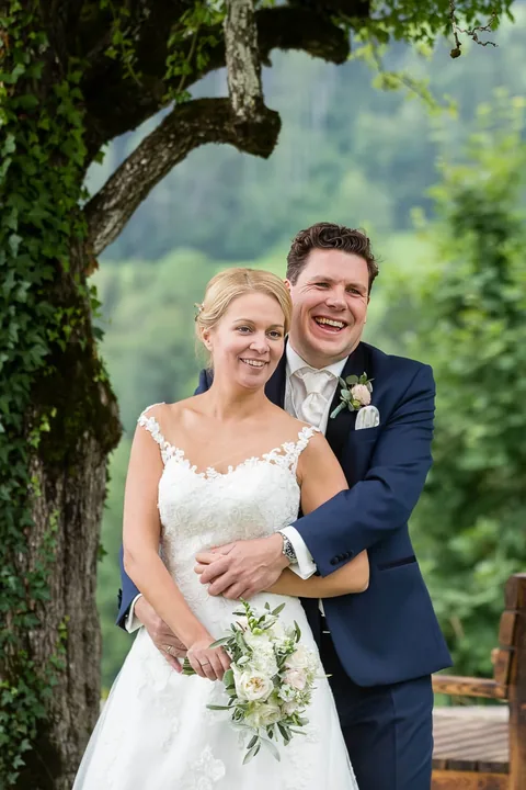Hochzeitspaar unter einem alten Baum bei einer Gartenhochzeit
