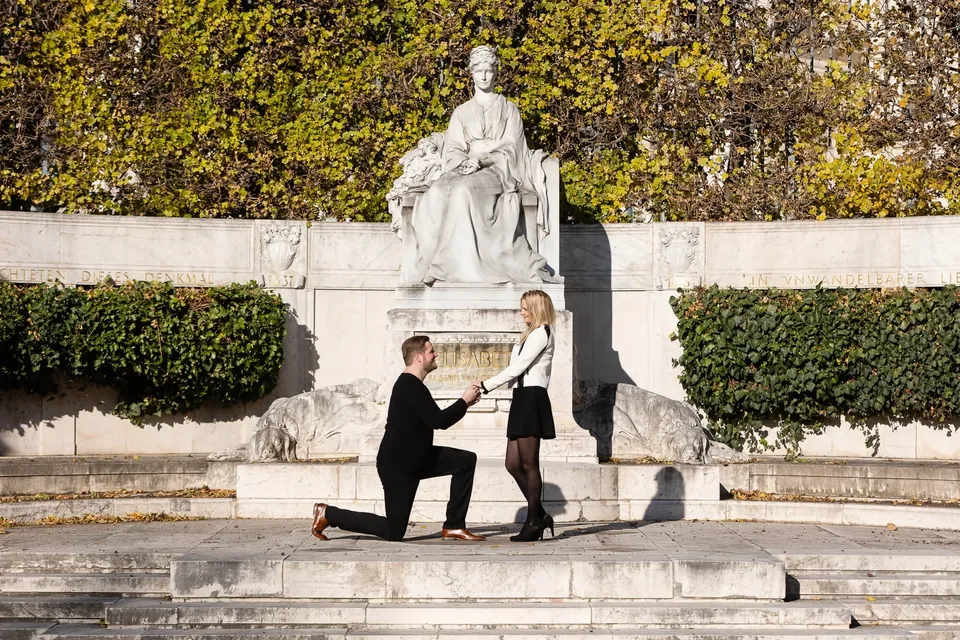 Marriage proposal on one knee at the Empress Elisabeth monument in Vienna's Volksgarten