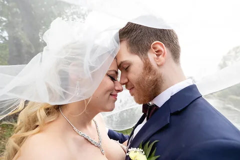 Nahaufnahme eines Hochzeitspaars unter dem Schleier