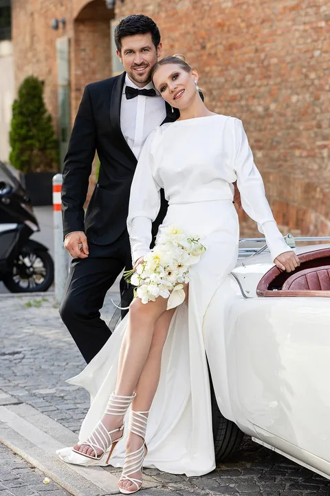 Hochzeitspaar mit weißem Oldtimer vor dem Palais Coburg