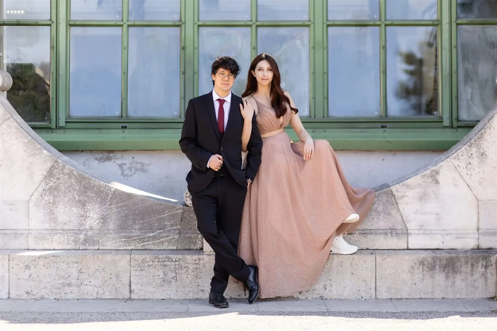 Elegant couple in front of the Palm House in Vienna's Burggarten