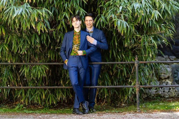 Engaged male couple in front of palm trees at Schönbrunn Palace